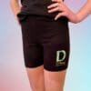 A person wearing black shorts with the letter d on them.