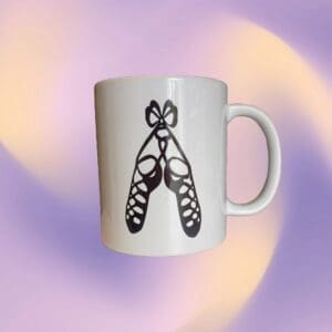 A white coffee mug with a butterfly design on it.
