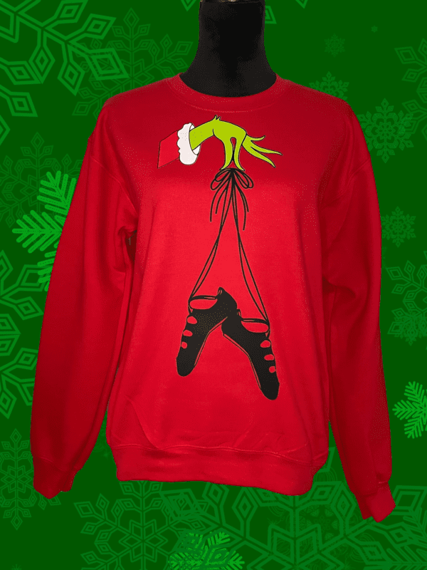 A red sweatshirt with a grinch hanging from the bottom of it.