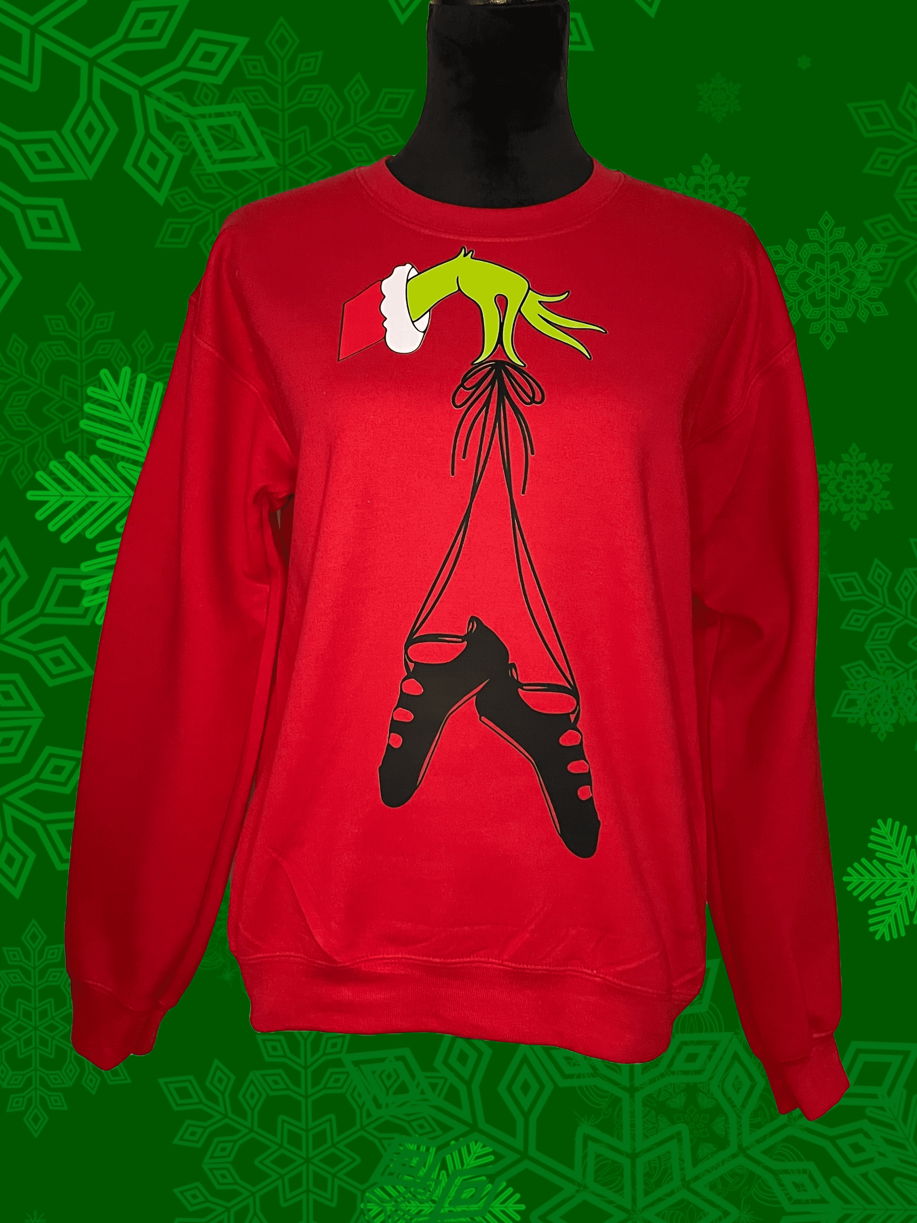 A red sweatshirt with a grinch hanging from the bottom of it.