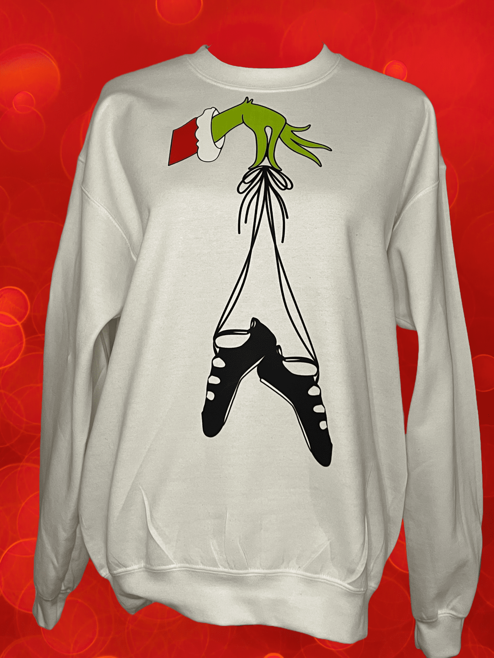 A white sweatshirt with the grinch hanging from it's legs.